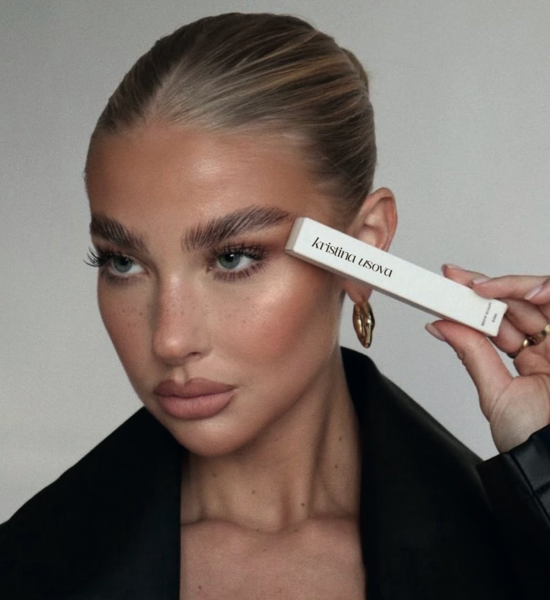 Editorial portrait — defined natural brows held with the Kristina Usova brow product.